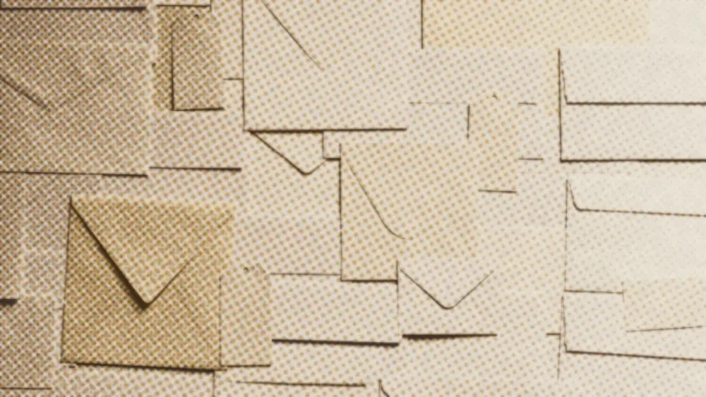 Blank cream and white envelopes overlapping edge to edge, photographed flat from above in warm light